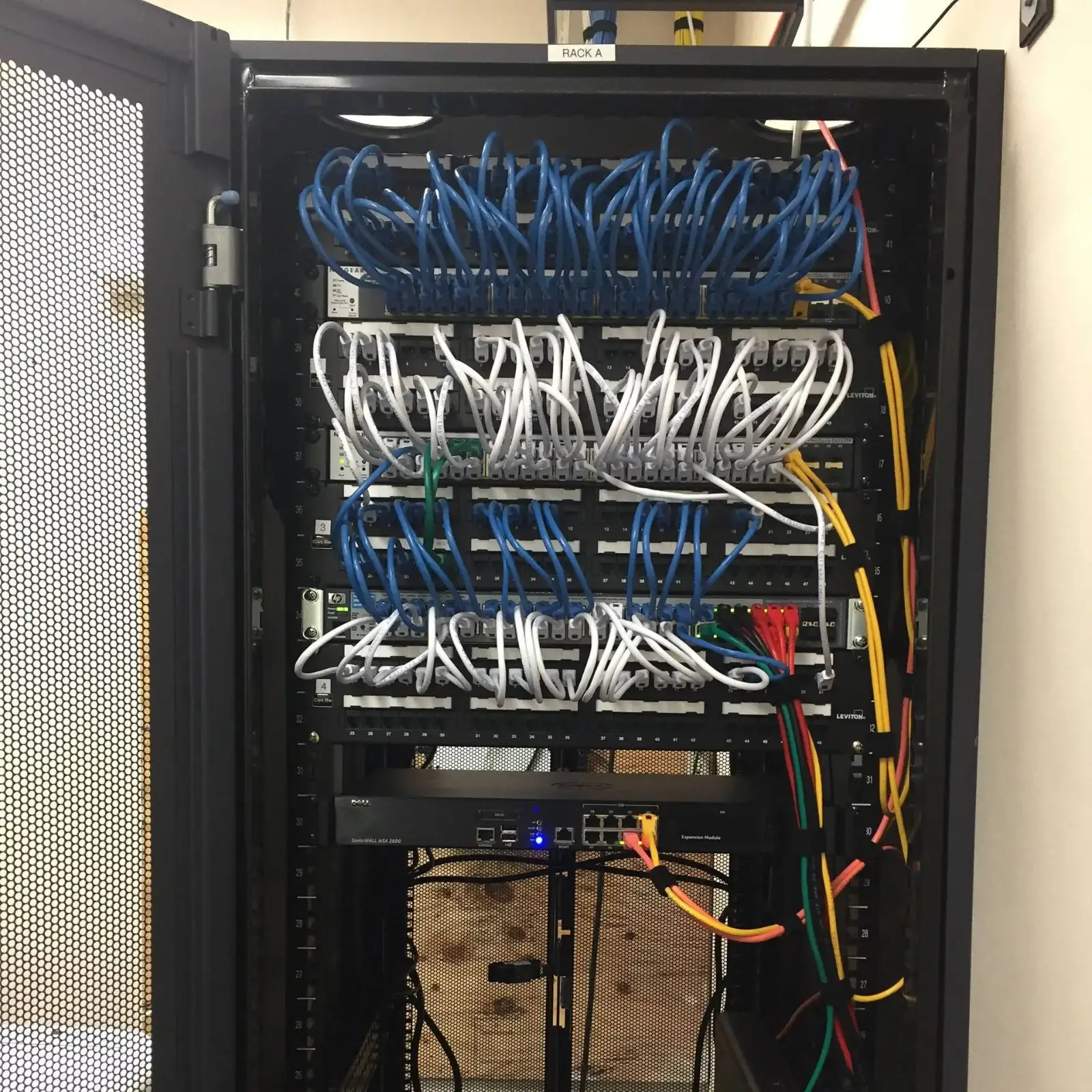 Network rack with color-coded blue and white patch cables
