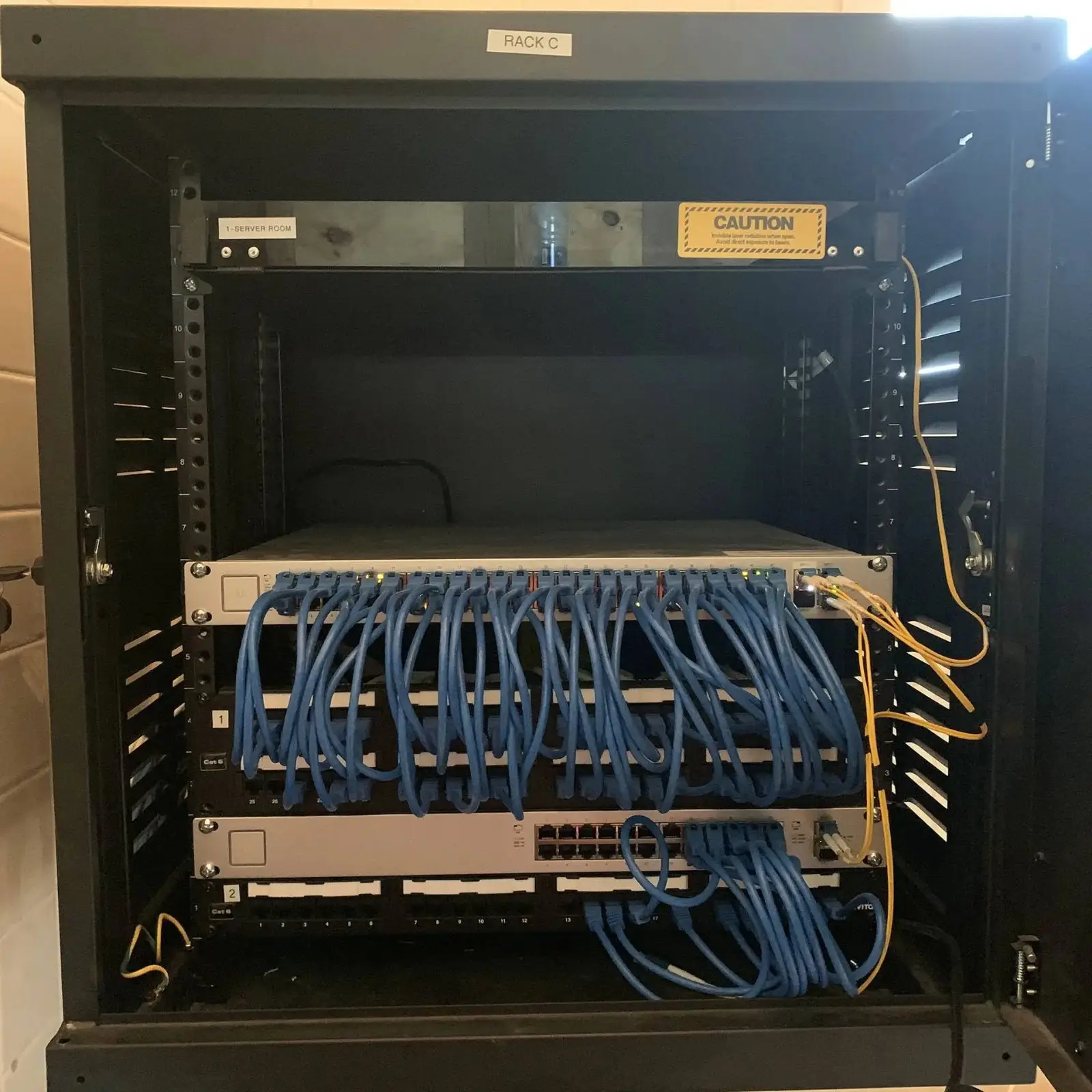 Network rack with organized blue patch cables between the switch and patch panel