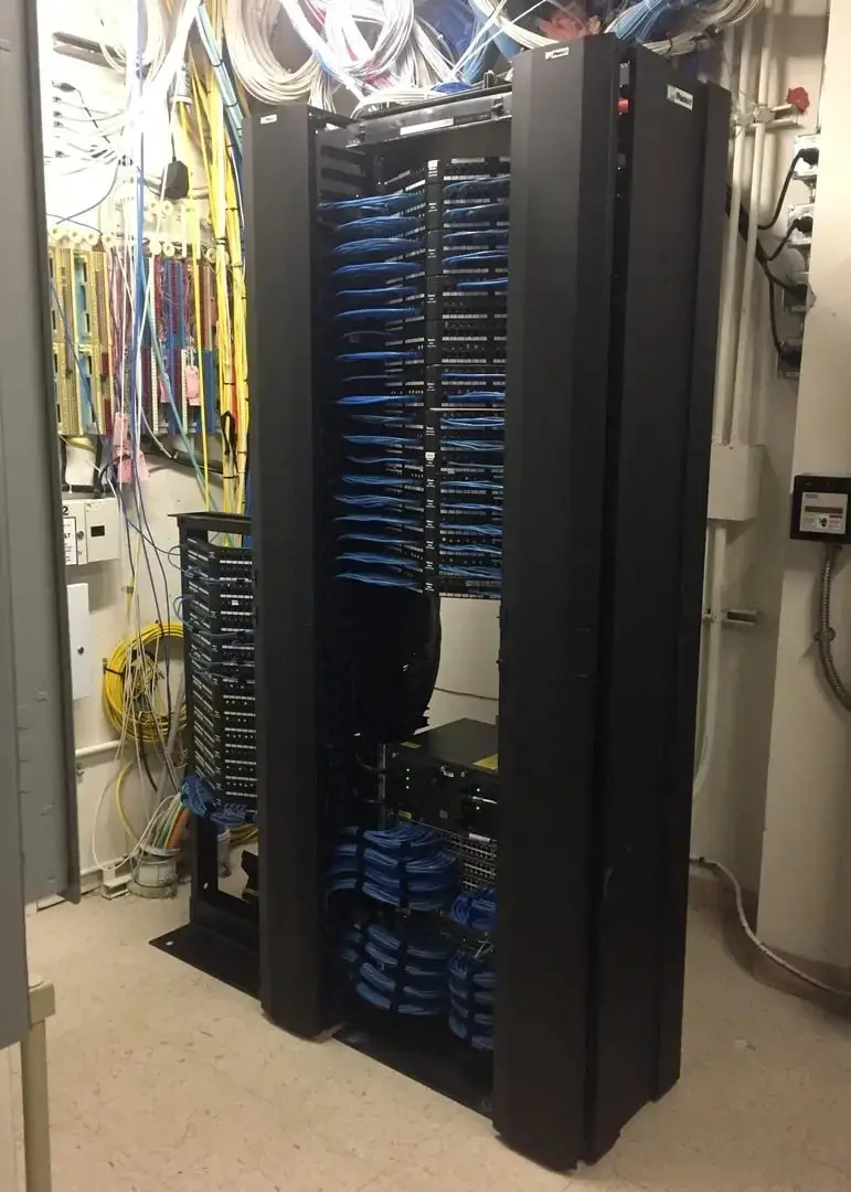The same network closet with organized, labeled cabling after a structured cabling install